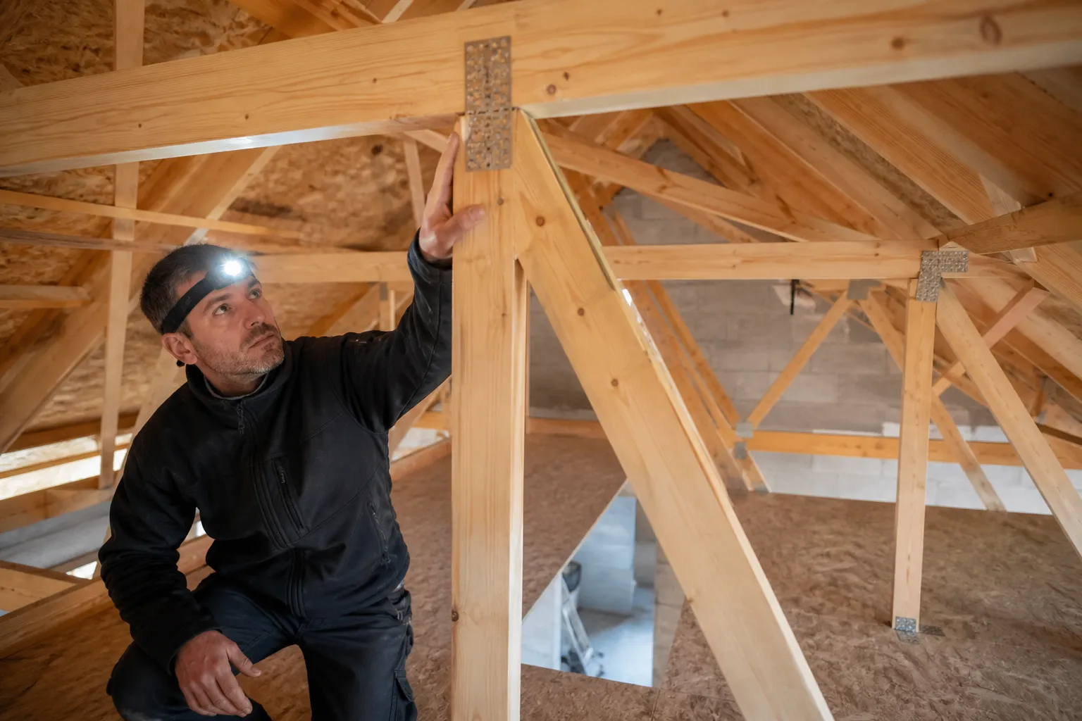 Expert en batiment inspectant la charpente d une maison neuve